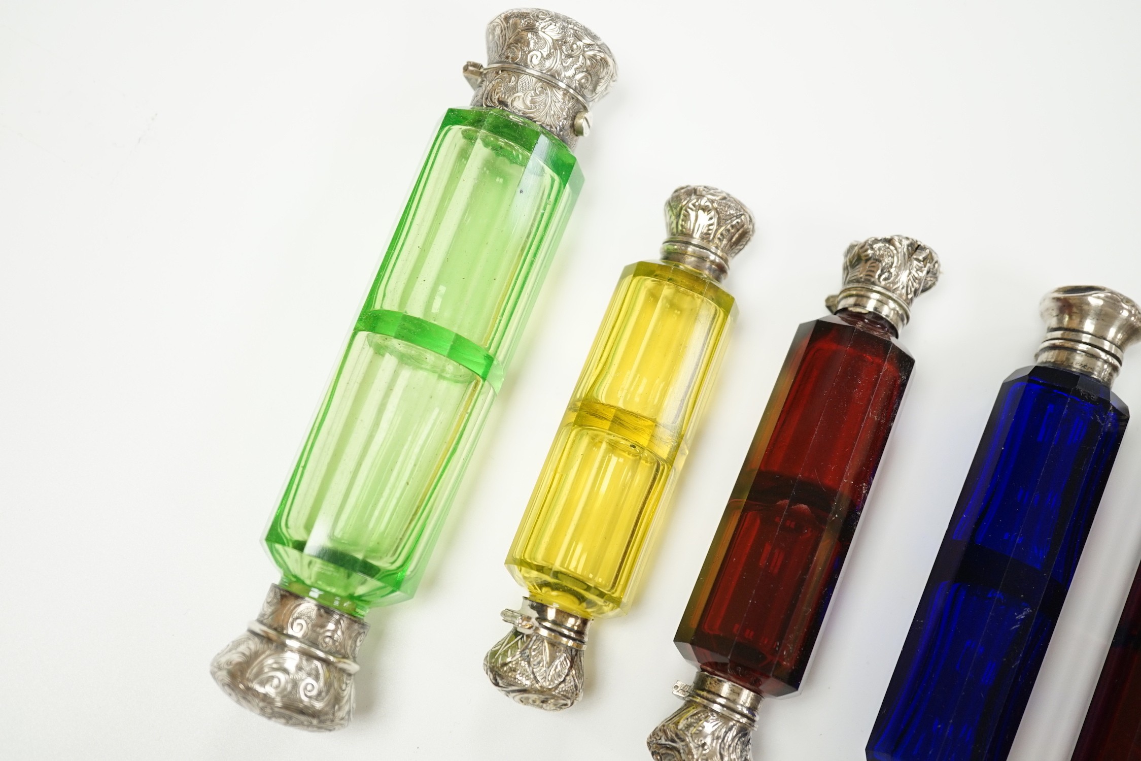 Six assorted late 19th/early 20th century white metal mounted coloured glass double ended scent bottles including pale green, 14.9cm and amethyst flash, 13.7cm (some a.f.)